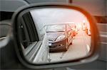 Wing mirror view of rows of traffic queueing on highway