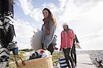 Young adult picnicking friends strolling along beach boardwalk, Western Cape, South Africa