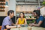 Woman and male friends chatting together in cafe