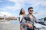 Young couple riding moped at harbour, Split, Dalmatia, Croatia