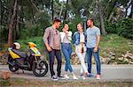 Two couples with moped chatting on rural road, Split, Dalmatia, Croatia