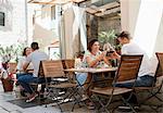 Young couples raising a wine toast at sidewalk restaurant, Split, Dalmatia, Croatia