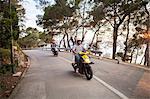 Two couples riding mopeds on rural road, Split, Dalmatia, Croatia