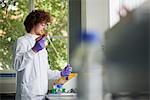 Scientist in laboratory using electronic pipette