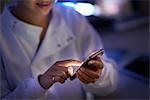 Scientist in laboratory texting on smartphone