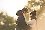 Young couple in rural setting, face to face, smiling