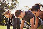 Man and two women doing push up training in park