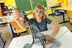 Boy with digital pen and 3D model of giraffe in classroom