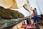 Traditional Sustainable Oyster Fishing.  A fisherman on a sailing boat.