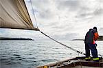 Traditional Sustainable Oyster Fishing, a fisherman on a sailing boat in the Fal Estuary.