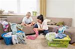 Woman with her son folding laundry in living room, Bavaria, Germany
