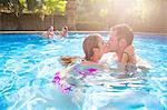 Couple in swimming pool kissing