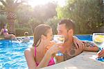 Couple in swimming pool enjoying a drink