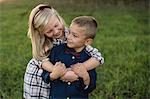 Sister hugging brother smiling