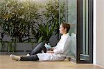 Young female doctor sitting on floor at hospital entrance