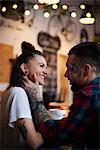 Couple in coffee shop face to face smiling