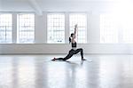 Side view of woman in dance studio in yoga position