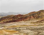 The landscape of the John Day Fossil Beds National Monument, Oregon. Vivid coloured rock strata. Mountains.