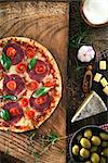 Fresh italian  pizza on wood. Pizza with cheese, salami and tomatoes. Fast food. Rustic pizza