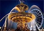 Fountain of Mars and ferris wheel on square of Concorde in evening Paris, France