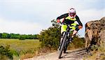 Professional Cyclist Riding the Bike at the Rocky Trail. Extreme Sport Concept. Free Space for Text.