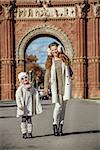 in Barcelona for a perfect winter. Full length portrait of happy trendy mother and child standing near Arc de Triomf in Barcelona, Spain