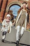 in Barcelona for a perfect winter. Full length portrait of smiling trendy mother and daughter near Arc de Triomf in Barcelona, Spain walking