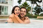 Young couple in a luxury hotel embraced inside a jacuzzi and enjoying the holidays