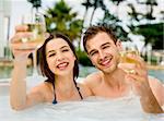 Young couple inside a jacuzzi and toasting