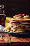 Homemade Pancakes with Maple Syrup, Strawberries and Banana. Vertical orientation.