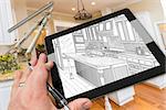 Hand of Architect on Computer Tablet Showing Drawing of Kitchen Photo Behind with Compass and Ruler.