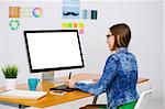 Woman working at desk In a creative office, using a computer