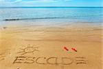 Escape message on the beach sand - vacation and travel concept