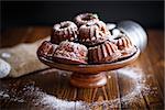 sweet honey muffins in powdered sugar on a wooden table
