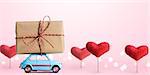 Blue retro toy car delivering gift box for Valentine's day on pink background with heart trees