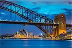 Cityscape image of Sydney, Australia with Harbour Bridge during twilight blue hour.