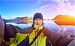 man hiker photographer taking selfie on the mountain lake background in Iceland
