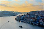 Overview of the harbour and the city of Porto along the Cais da Ribeira on the Douro River at sunset in Portugal