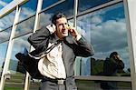 Business man with phone in wind