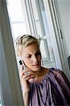 Woman at window using cell phone