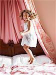 Girl jumping on a bed