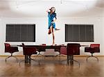 Young woman dancing on boardroom table