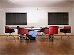 Man hiding under boardroom table