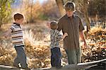 Father playing with young sons on log