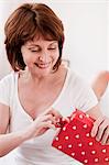 woman smiling opening gift