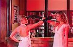 two girls at bar with plastic guns