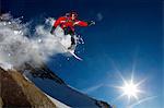 Snowboarder jumping off a rock.