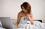 woman in bed using computer in bed