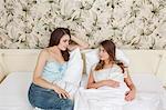 two young women in bed,talking