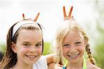 2 young girls smiling giving rabbit ears
